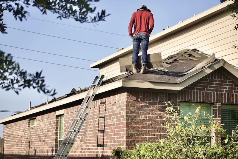 Professional roofer working on a residential roof in Preston Hollow